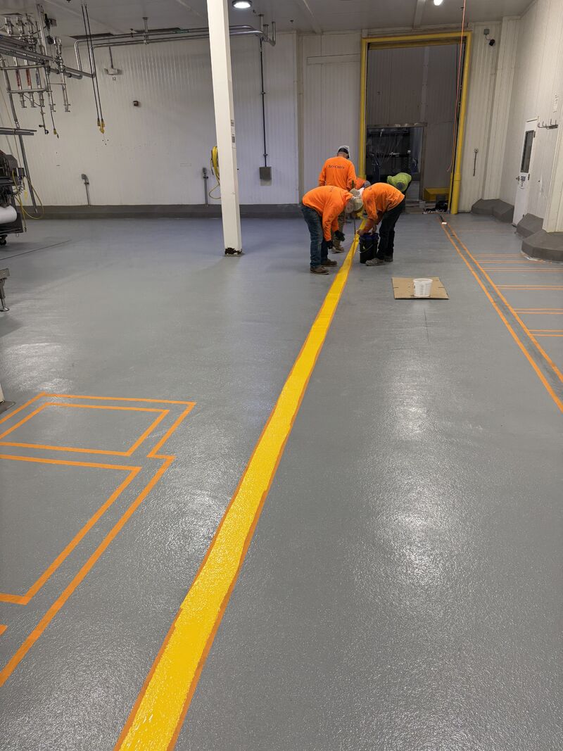 Professional installation of 5S floor marking system using specialized equipment to integrate lines directly into resinous flooring for permanent, washdown-resistant marking