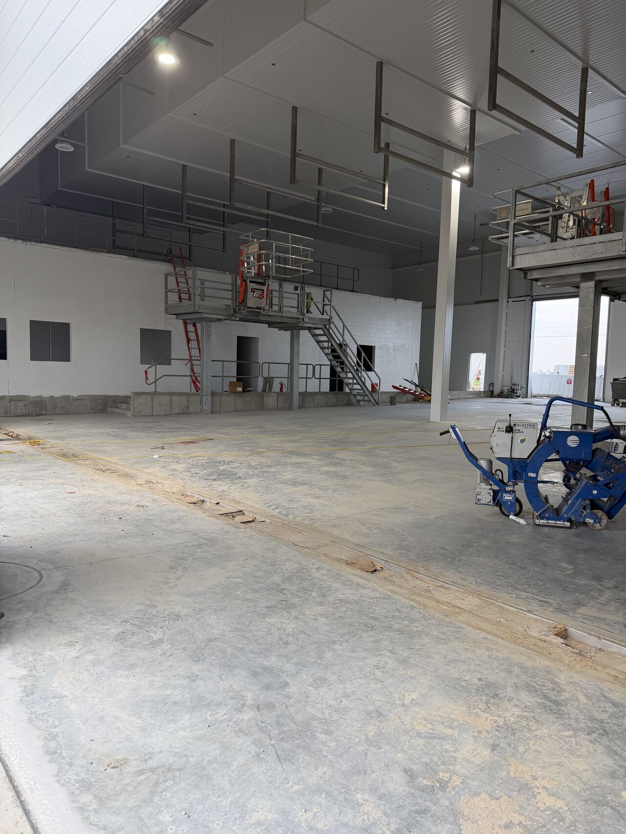 Shot blasting equipment on a prepared dairy plant slab