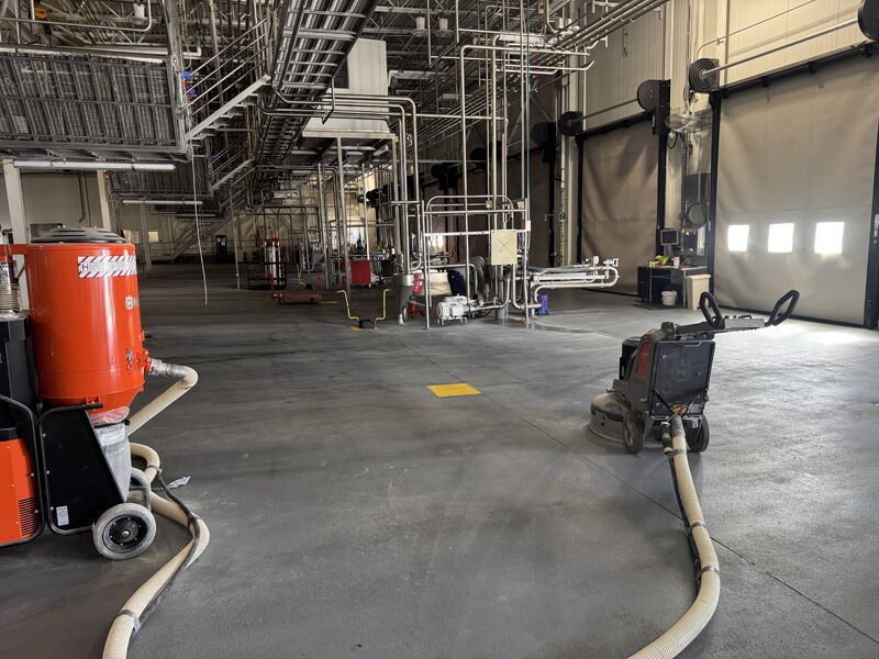 Dairy production space with floor grinding equipment during SaniQuartz shutdown resurfacing