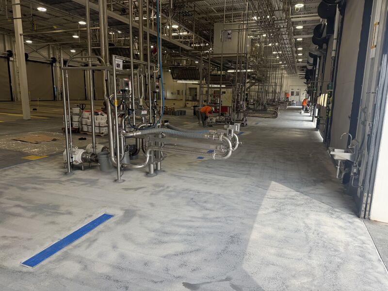 Broad dairy floor area prepared for SaniQuartz resurfacing before final top coat