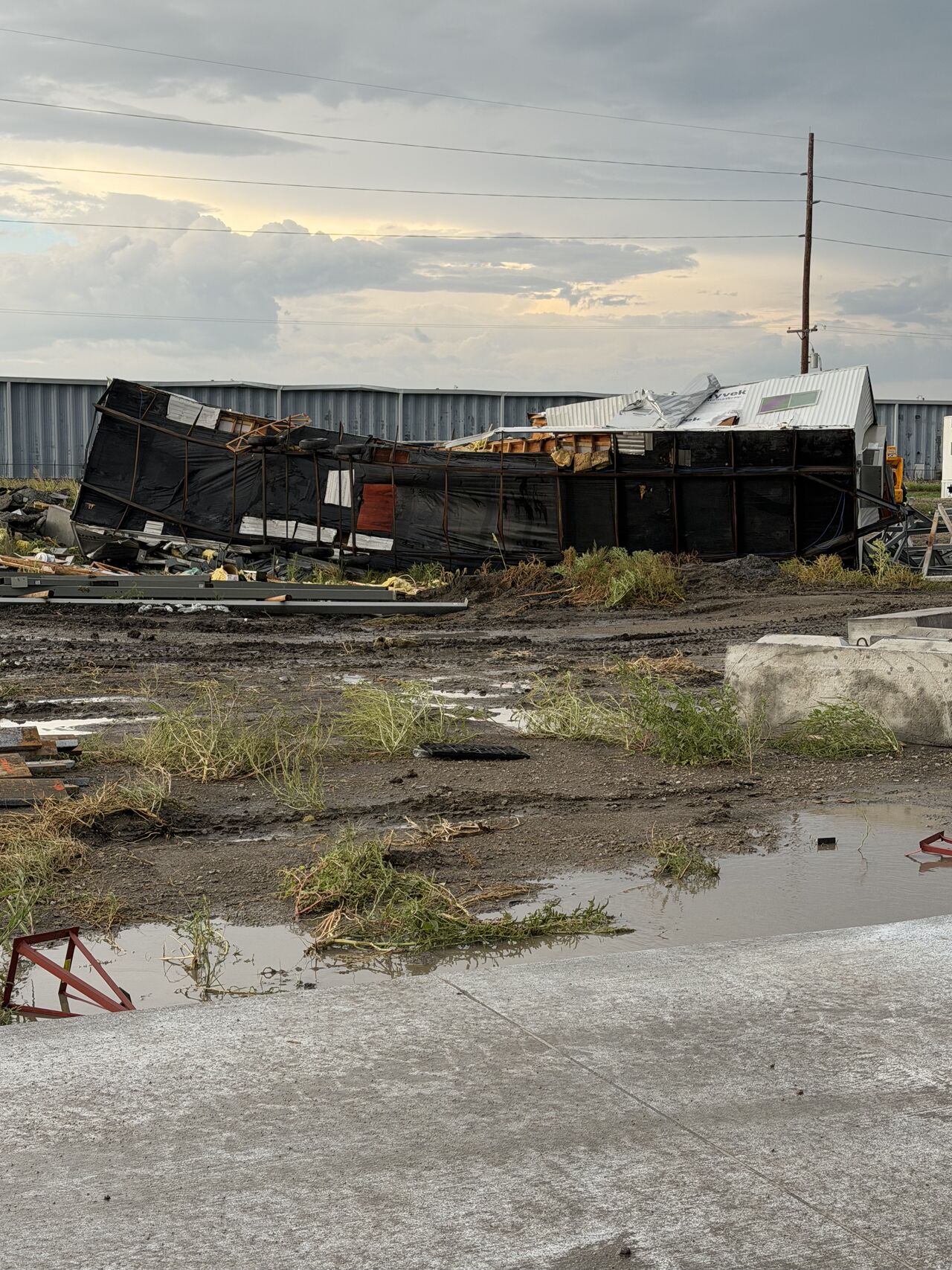 Collapsed trailer and jobsite structure after a tornado at a new dairy construction project
