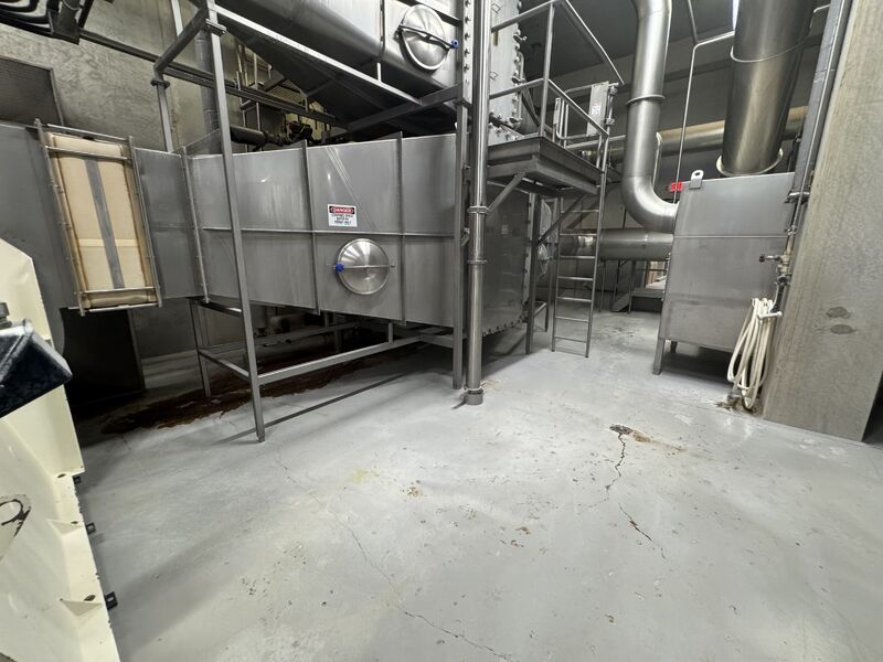Worn cracked concrete floor with chemical staining in food processing facility before SaniCrete installation
