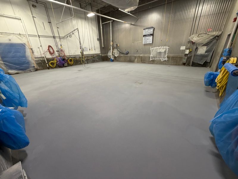 Completed gray SaniCrete floor with drains and integral cove base ready for production equipment