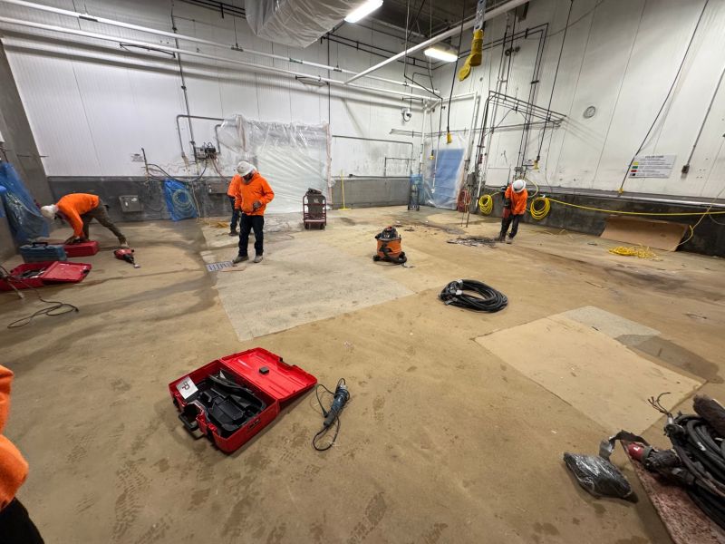 SaniCrete crew beginning floor removal in a cleared production room