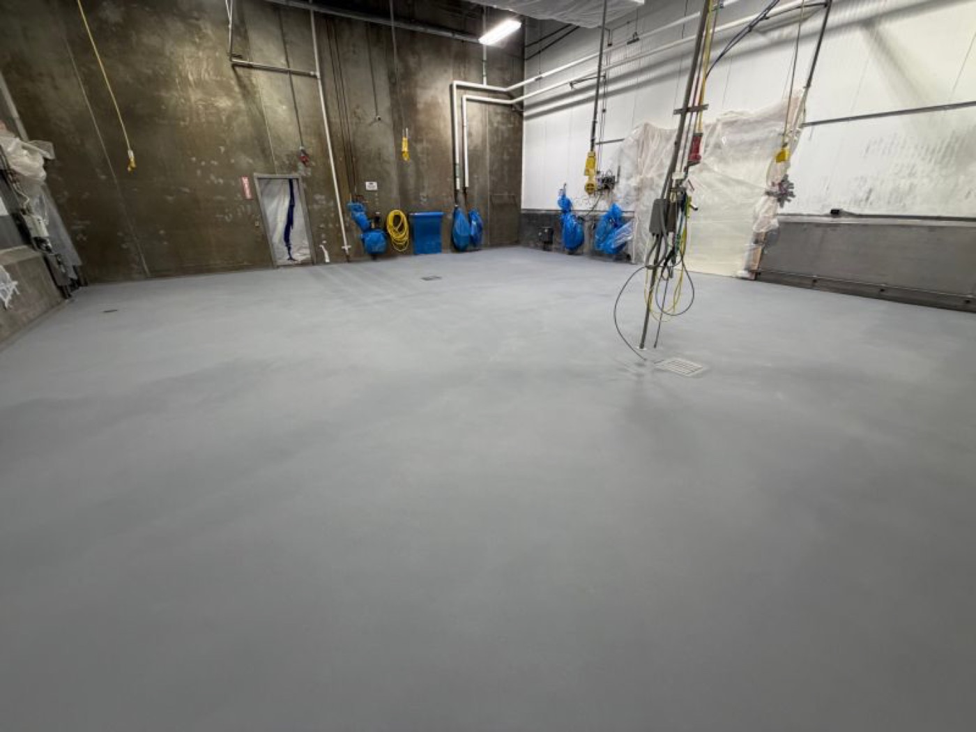 Finished seamless gray SaniCrete STX floor in an empty production room before new equipment installation