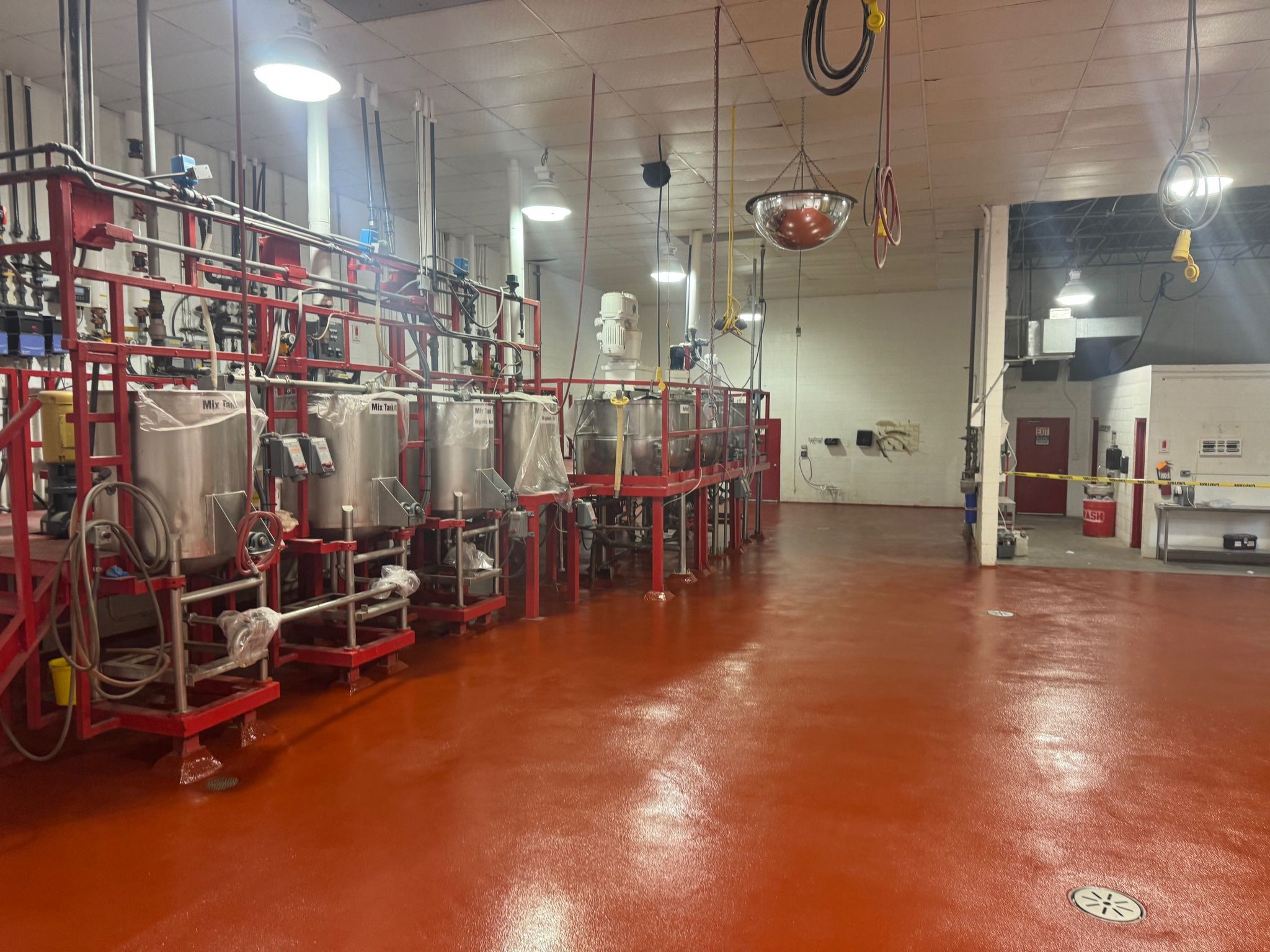 Completed red STX floor with new round top drains in production room