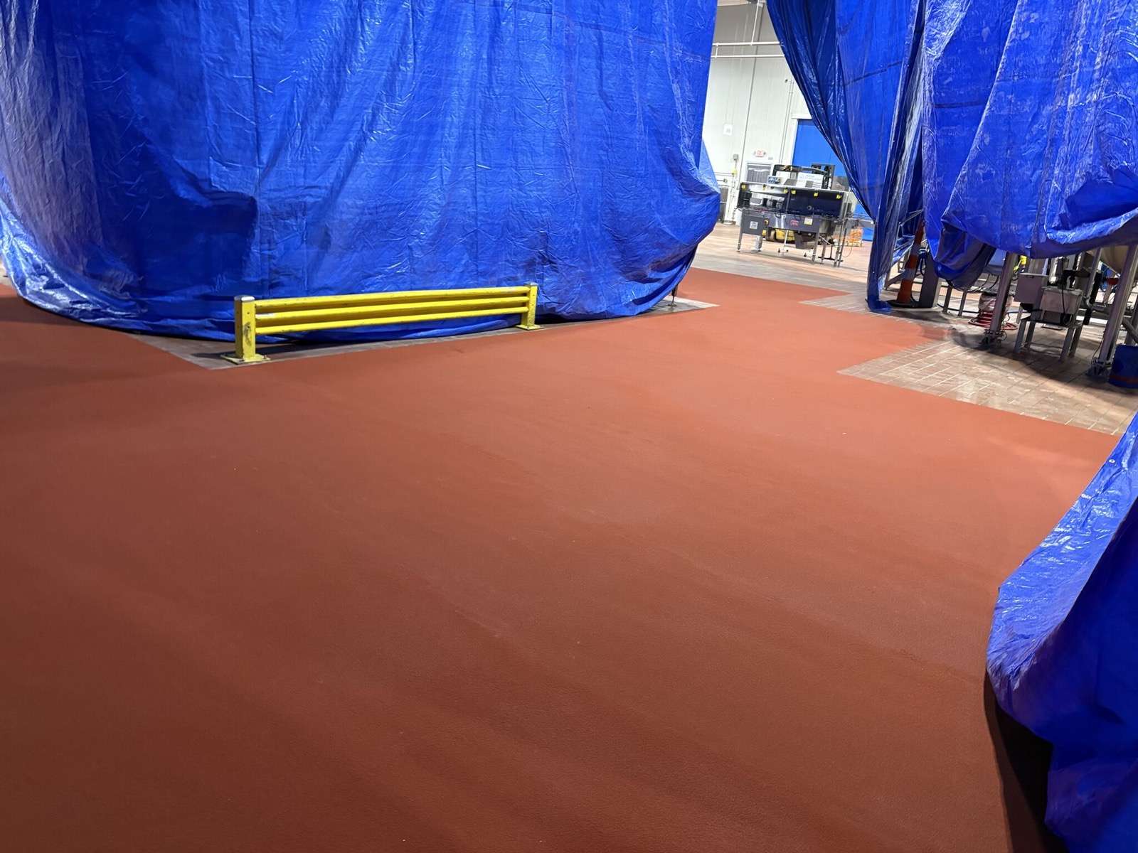 Finished red SaniCrete STX floor installed through a food plant traffic path after failed tile was removed