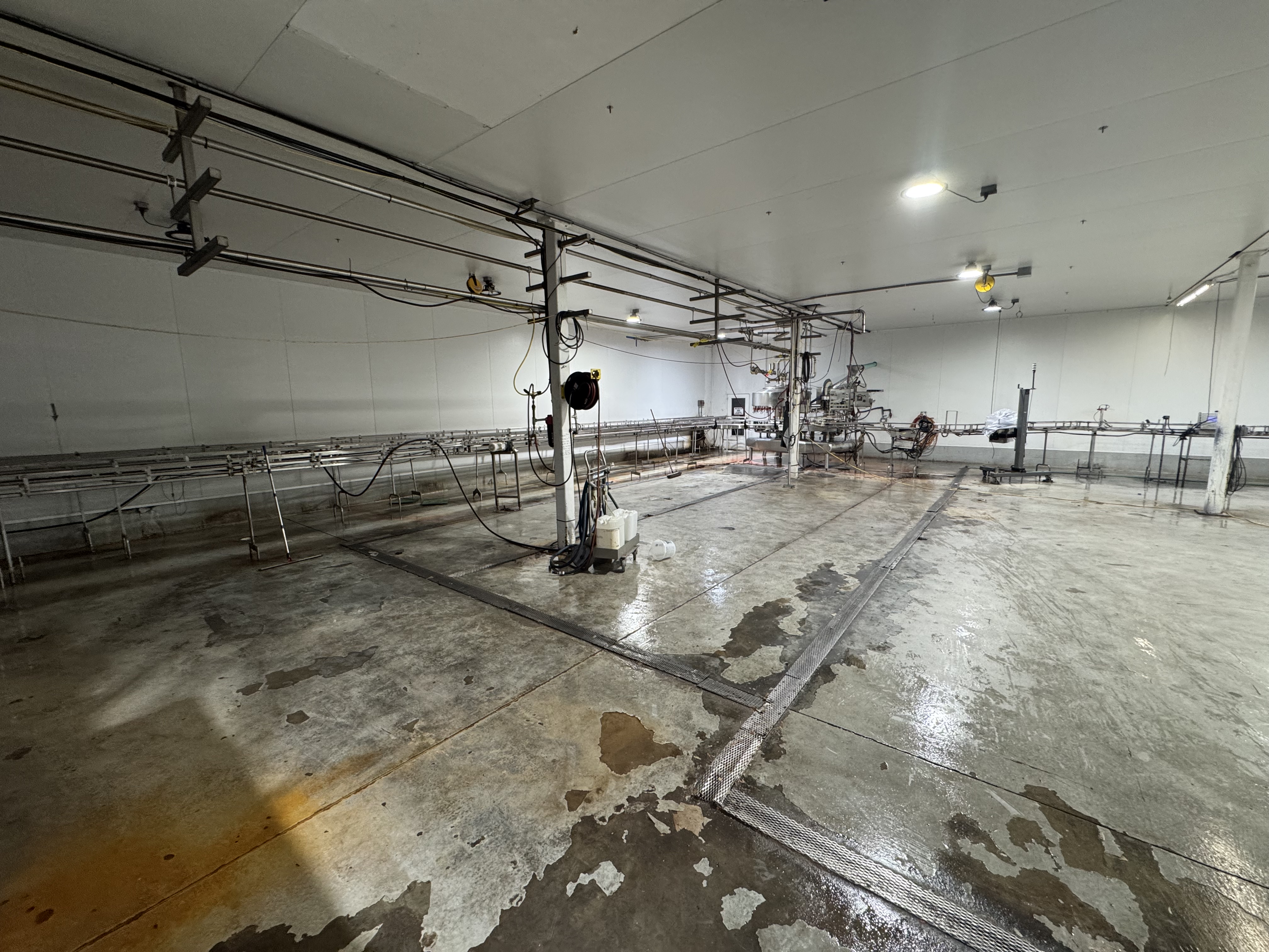 Juice processing facility floor before SaniCrete installation - damaged and deteriorating concrete