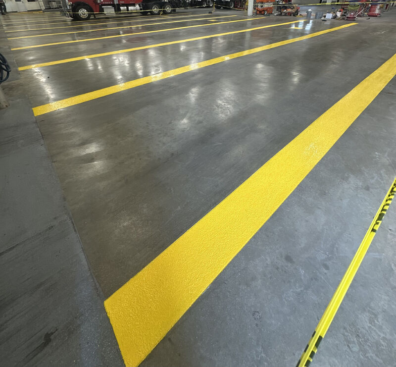 Yellow non-slip line striping on warehouse floor