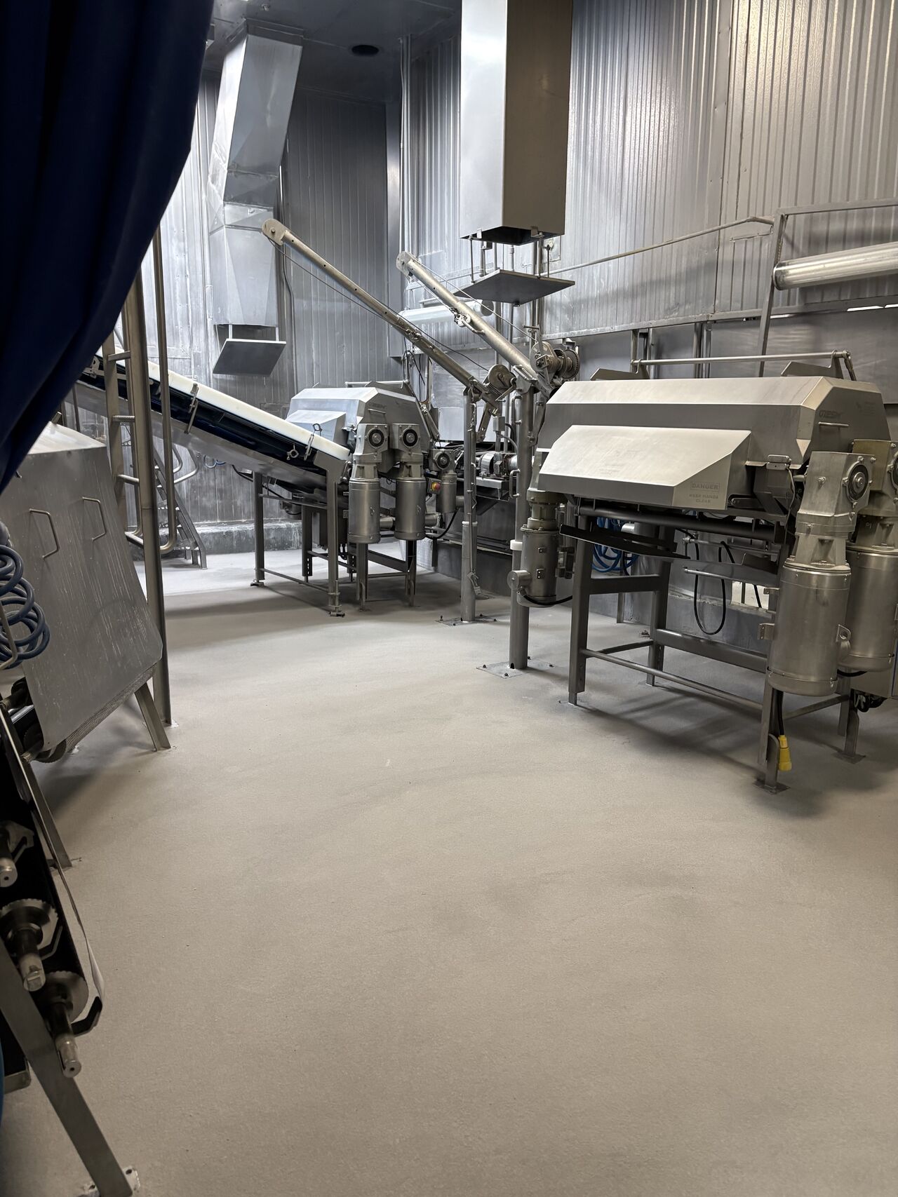 Completed SaniCrete STX floor under conveyor and processing equipment in meat processing facility