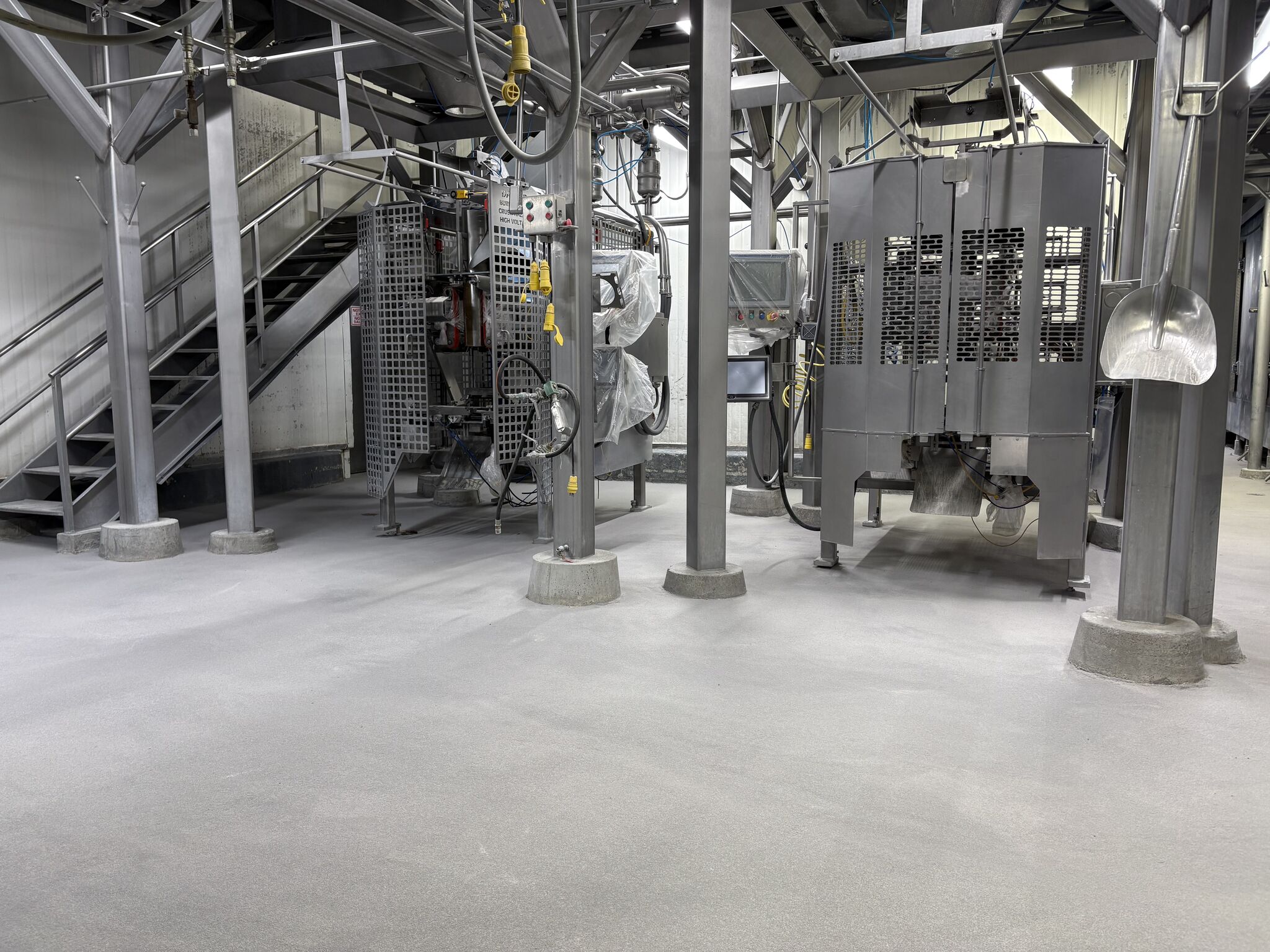 Completed SaniCrete STX floor around heavy processing machinery in meat processing facility