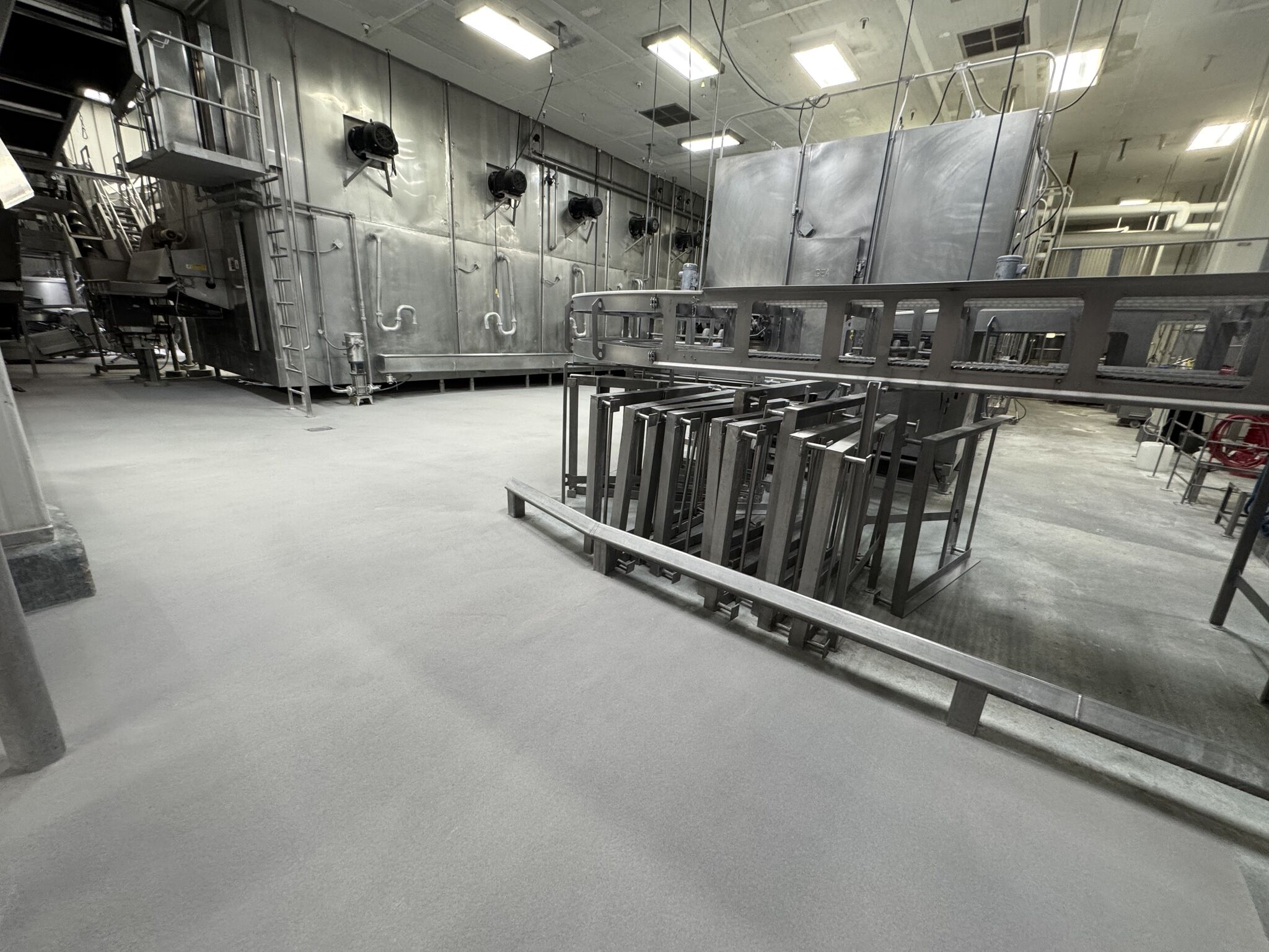 Completed SaniCrete STX floor in meat processing production area with stainless steel equipment