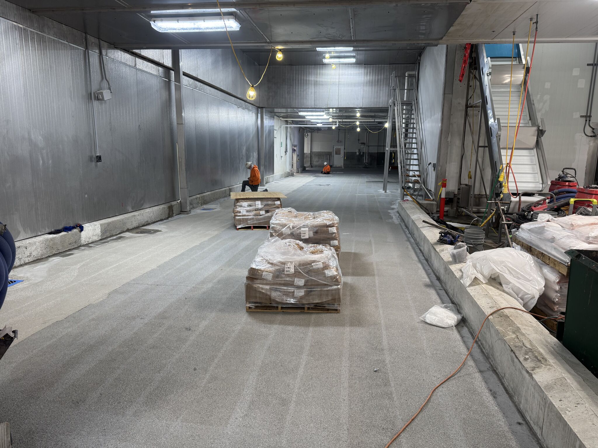 SaniCrete crew preparing oven room floor with materials on pallets ready for STX installation