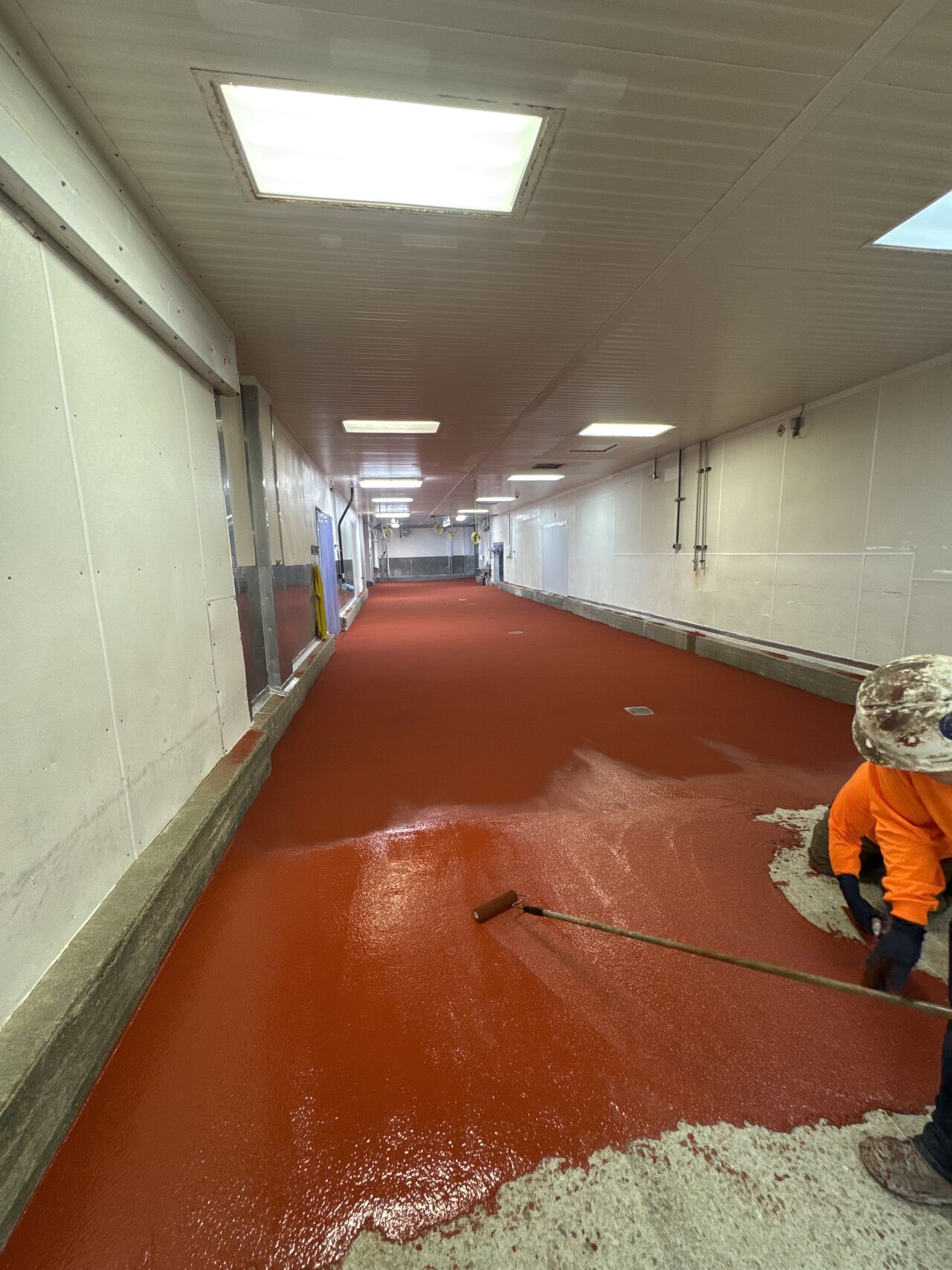 SaniCrete installer rolling out STX cementitious urethane topcoat in oven room