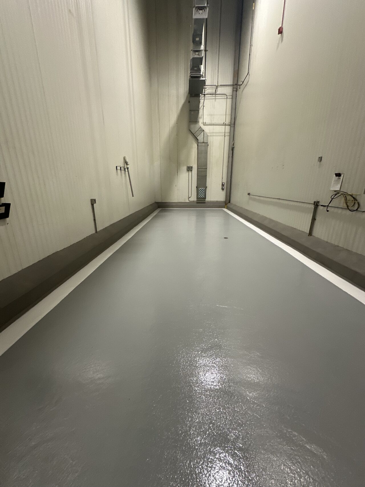 Completed spice room — seamless gray SaniCrete floor with white line striping and curbing