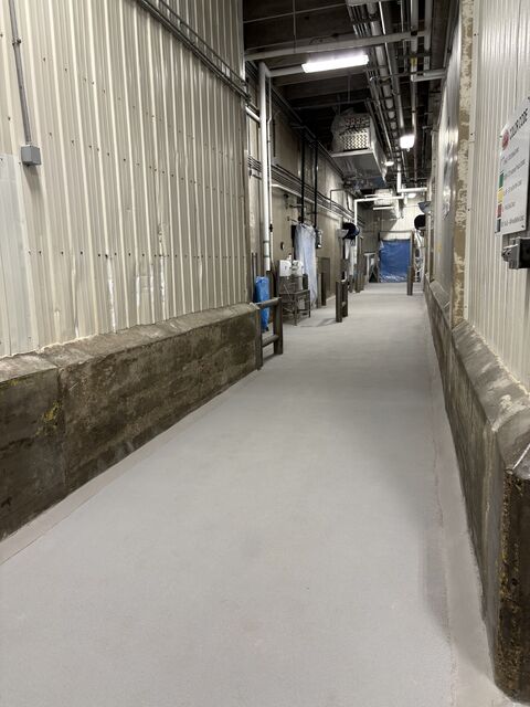 Finished gray SaniCrete STX floor in a washdown-ready food processing corridor